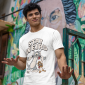 gildan-t-shirt-mockup-of-a-man-standing-in-front-of-a-painted-wall-m39287